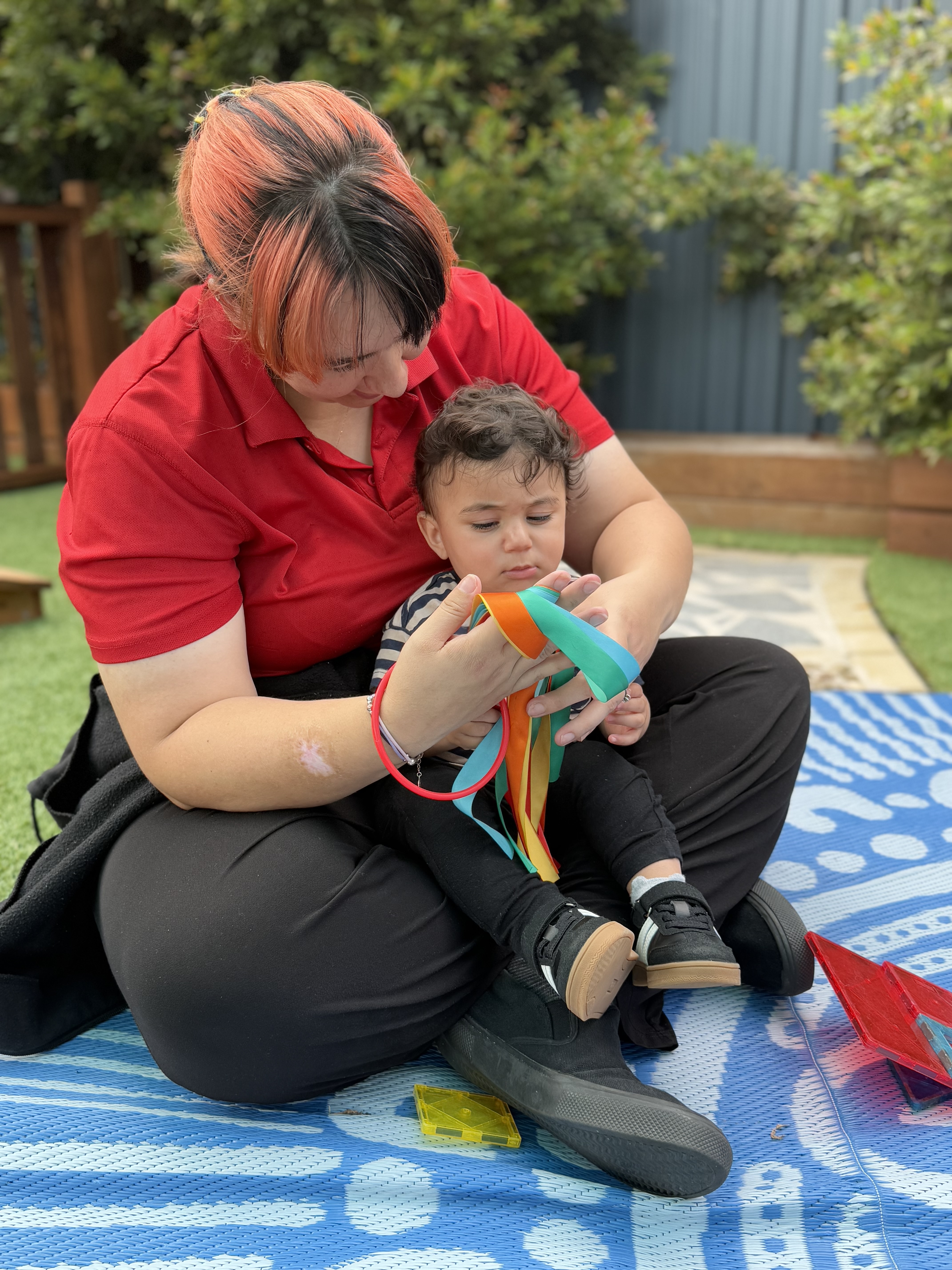 Educator helping a young child with a toy